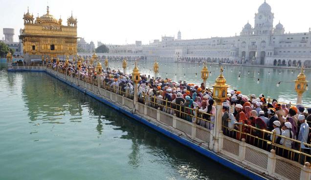 Los devotos hacen cola para pagar homenaje en el Templo Dorado de Amritsar el sábado en la víspera del cumpleaños 541 de Guru Nanak Dev.