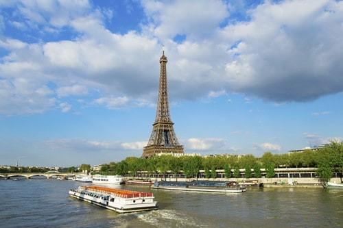 La torre Eiffel y una barcaza turística sobre el río. 